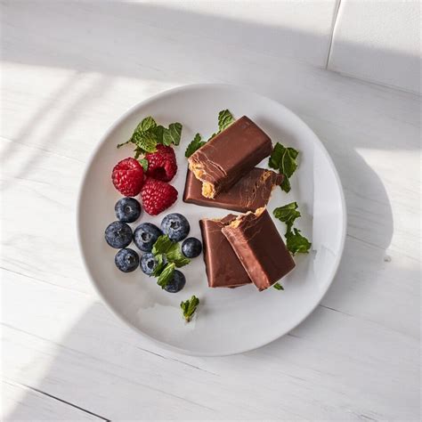 Darčeková krabička plná zdravých maškŕt: proteínové tyčinky, orechové maslá a sušené ovocie.