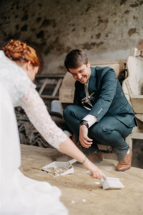 Fotografia novomanželov pri zametaní črepín z rozbitého taniera ako symbolu šťastia.