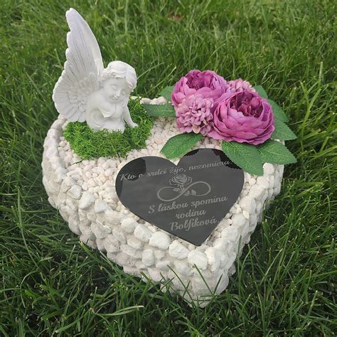 Hrob s horiacou sviečkou a kvetmi symbolizujúci spomienku