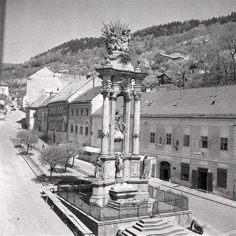 Architektonický pohľad na Radničné námestie v Banskej Štiavnici s kvetinárstvom v popredí.