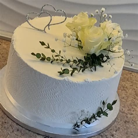 jednoduchá, viacposchodová svadobná torta ozdobená čerstvým ovocím a listami v rustikálnom štýle