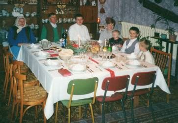 Tematické foto rodiny pri štedrovečernom stole s tradičnými jedlami a výzdobou