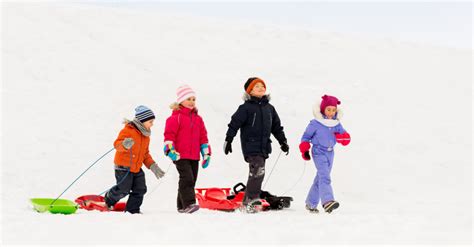Deti sánkujúce sa na zasneženom kopci