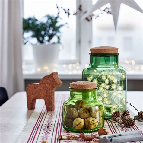 Sklenené nádoby s vianočnými dekoráciami a svetielkami