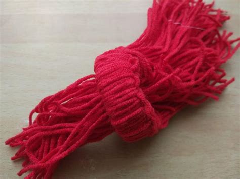 Škriatok vyrobený zo šišky s filcovou čiapkou a šálom.