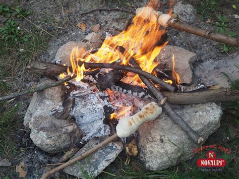 Deti opekajú chlieb na paličke nad ohniskom