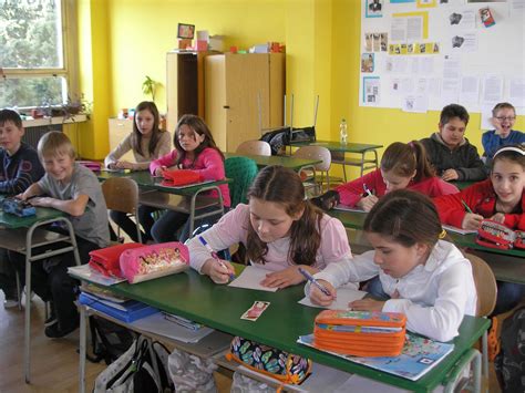 Skupina šťastných žiakov v triede s učiteľom