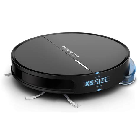 Robotický vysávač upratuje podlahu v obývacej izbe, zatiaľ čo staršia žena sedí v kresle.
