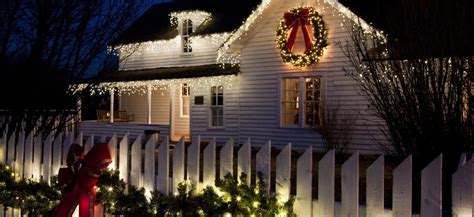 Vianočne ozdobený exteriér domu s kvetináčmi plnými zelene a svetielok