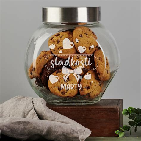 sklenená nádoba s cukríkmi a zrolovanými bankovkami pomedzi ne