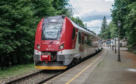 Vlak ZSSK v zimnej krajine s jemným vianočným motívom v pozadí