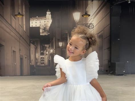 ilustračné foto detí v bielych šatách pred kostolom symbolizujúce čistotu a slávnostnosť okamihu