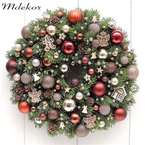 Vianočný veniec z ihličnatých vetvičiek ozdobený guľami a stuhami.