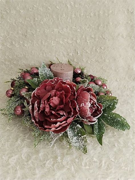 Stolová dekorácia s vianočnou sviečkou a vetvičkami.