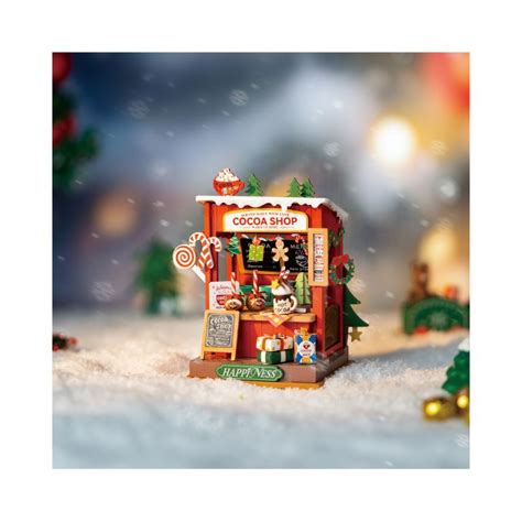 Detailný záber na osvetlený vianočný stánok s rôznymi dekoráciami.