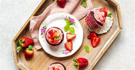 Krásne ozdobené valentínske cupcakes s jahodovým krémom a farebným cukrom.