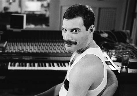 muž v kostýme Freddieho Mercuryho s mikrofónom