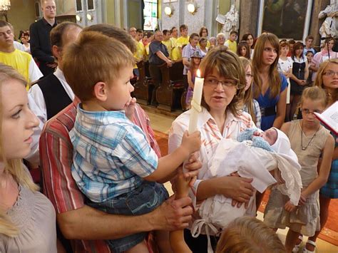 Tematické foto: Skupina ľudí v kostole, pravdepodobne rodičia a krstní rodičia dieťaťa