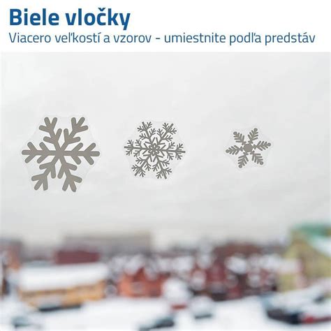 Vystrihnuté papierové vločky a hviezdy prilepené na okne.