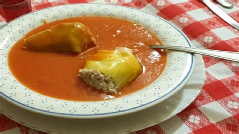 4 plnené papriky v paradajkovej omáčke na tanieri s bylinkovým jogurtom