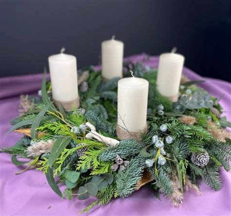 Snímka tradičného adventného venca s horiacimi sviecami v prírodnom štýle