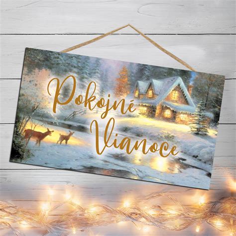 Zimná zasnežená krajina s domčekmi a svetielkami