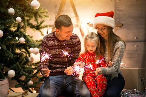 Tematická fotografia šťastnej rodiny pri vianočnom stromčeku alebo záber blikajúcich vianočných svetiel