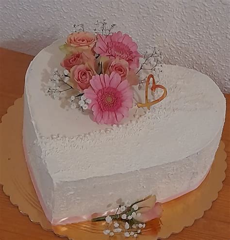Sviatočne vyzdobená biela torta s náboženskými symbolmi a čerstvými kvetmi