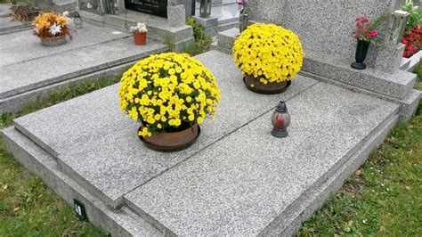 Tematické foto detailne naaranžovaného hrobu s chryzantémami a sklenenými kahancami