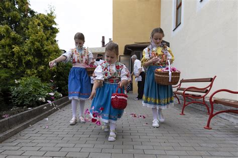 Deti v krojoch alebo kostýmoch koledníkov pri dome, píšuce kriedou na dvere nápis C+M+B.