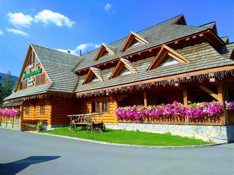 The exterior of Hotel Strachanovka in Liptovský Ján, showing its rustic wooden architecture surrounded by mountains.