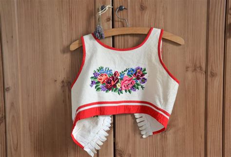 Detail tradičnej slovenskej výšivky s kvetinovými a geometrickými vzormi, ktorá by mohla byť inšpiráciou pre tortu.