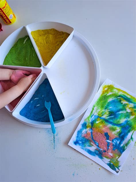 Dieťa maľuje farebným pieskom na pripravenú šablónu.