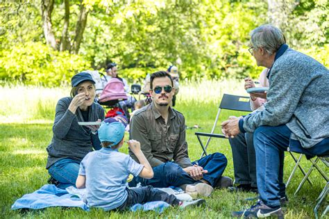 Záber na japonský park plný rozkvitnutých sakúr s ľuďmi počas pikniku