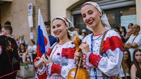 Fotografia dievčaťa polievaného vodou z vedra v tradičnom prostredí.
