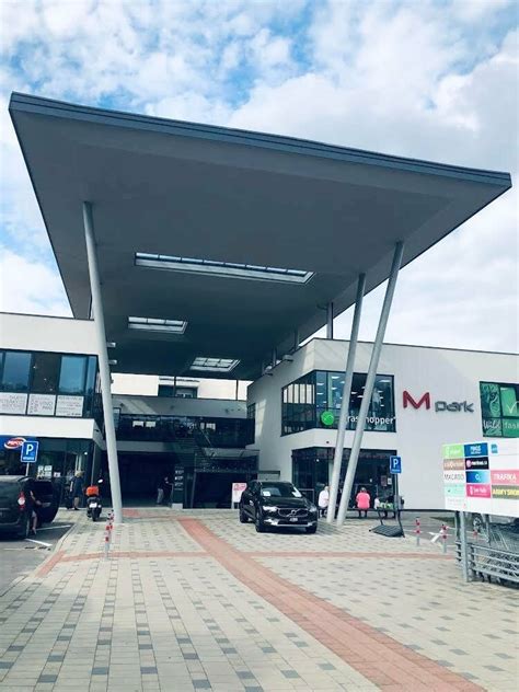 Autokino s veľkým plátnom a zaparkovanými autami za súmraku