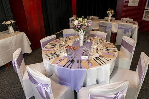 Svadobné stoly s modrými obrusmi a kvetinovou výzdobou