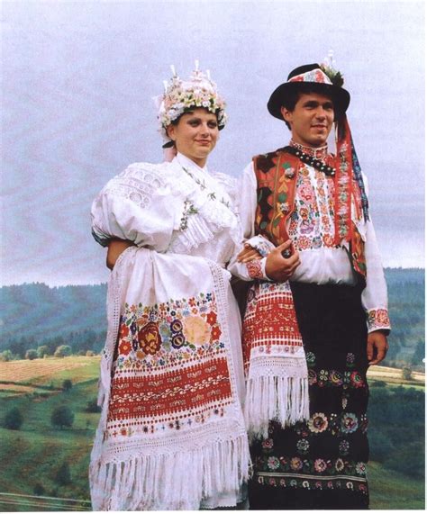Koláž tradičných slovenských svadobných symbolov: kroj, svadobný koláč, pierko a svadobný závoj.