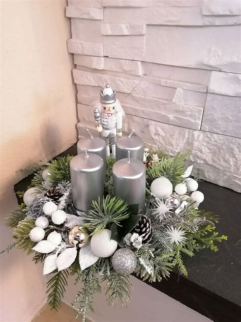 elegantný biely adventný svietnik so striebornými detailmi a zasneženým efektom