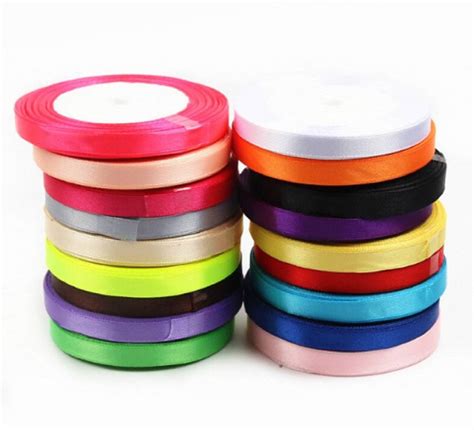 Fotografia materiálov: polystyrénová guľa, farebné saténové stuhy, špendlíky a pravítko