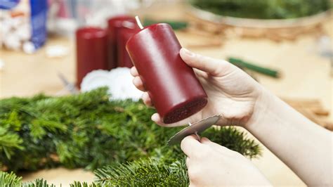 Upevnenie sviečok na adventný veniec pomocou držiakov alebo drôtu.