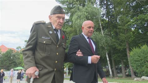 Ilustračná fotografia účastníkov osláv SNP, ktorí stoja pod dáždnikmi.