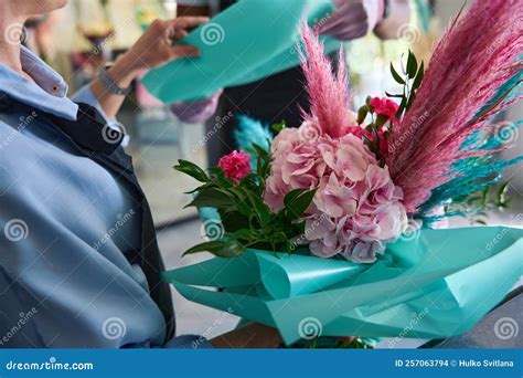 Florista odovzdávajúci elegantne zabalenú kyticu