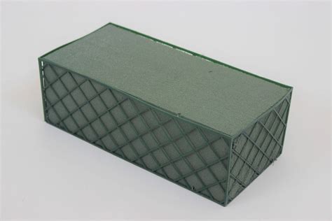 Detailný záber na aranžérsku hmotu (florex) v miske s napichanou zeleňou a sviečkami