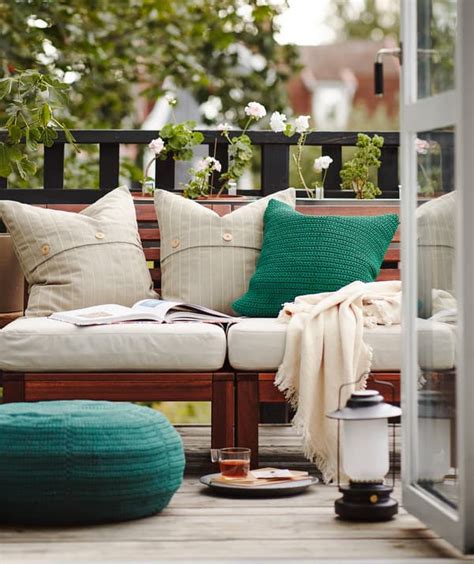 Záber na útulnú obývačku s množstvom vankúšov, diek a svetelných reťazí pripravenú na pyžamovú párty