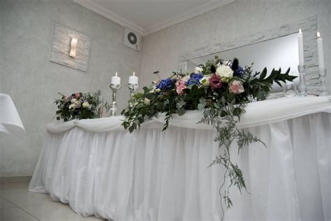 štýlový hlavný svadobný stôl s kvetinovou výzdobou a sviečkami