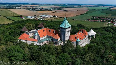 Panoramatický pohľad na zasnežený Smolenický zámok obklopený lesmi Malých Karpát v zimnom období