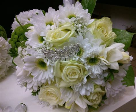 Svadobná kytica a dekorácie na stôl vo farbe šampanského.