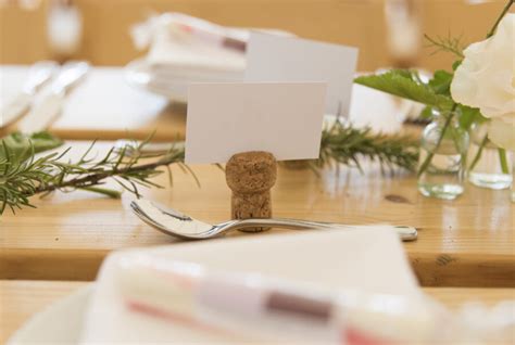 ukážka rôznych DIY svadobných dekorácií: menovky z korku, origami kvety, stuhy na stoličkách