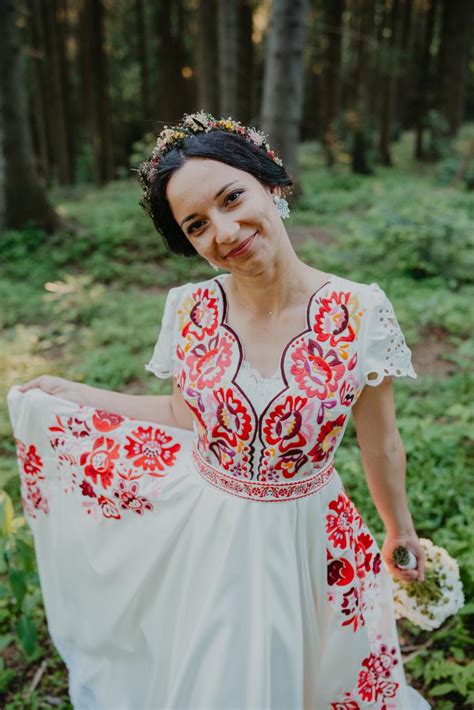 Ukážka stola vyzdobeného vo folklórnom štýle s ľanovým obrusom, folk štólou a lúčnymi kvetmi v zaváraninových pohároch